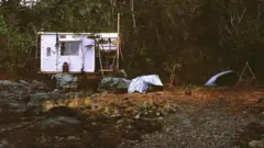 Cabana de Bob Kull na Patagônia, construída com madeira compensada e lonas de plástico sobre postes