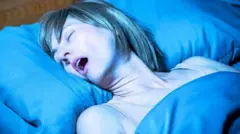 මුඛය විවරව නිදා සිටින කාන්තාවක්