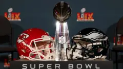 Di Super Bowl trophy and Chiefs and Eagles helmets