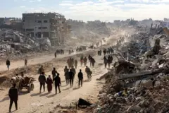 20 Ocak 2025'te Gazze Şeridi'nin kuzeyindeki Cibaliye'deki Saftawi Caddesi boyunca insanlar yıkılmış binaların enkazının arasından yürüyor.
