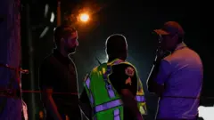 Law enforcement officers talk to each other after reports of shots fired outside Donald Trump's golf course