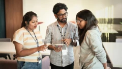 කාර්යාලය කතා බස් කරමින් සිටින සේවකයින් තිදෙනෙකුගේ ඡායාරුපයකි