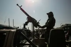 یو پوځي دشتکې ته په رېنجر ګاډي کې ناست دی او د دشتکې خوله یې اسمان ته نیولې چې مرمۍ ترې راځوړندې دي.