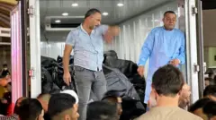 মৃতদেহ ভর্তি ট্রাকের কাছে মানুষের ভিড়। 