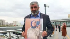 Nizamettin Kabaiş, 2024'te hayatını kaybeden kızı Rojin Kabaiş'in fotoğrafınnı gösteriyor 
