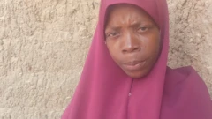 Maryam woman wearing read Hijab tell tori pipo say she lose two children for di boat accident