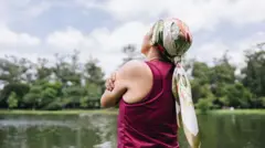 Mulher com lenço na cabeça num parque