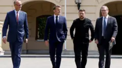 Umukuru wa reta y'Ubudagi Friedrich Merz, Perezida Emmanuel Macron w'Ubufaransa, Perezida Voloydmyr Zelensky wa Ukraine, hamwe n'umushikiranganji wa mbere w'Ubwongereza Keir Starmer bariko bagendagenda hanze y'ikirimba ca Mariynsky i Kyiv muri Ukraine.