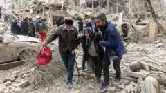 Tow women dey carry one elderly woman by hand . Di woman dey use walking stick.