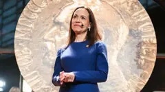 María Corina Machado, vistiendo un vestido azul.