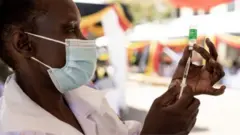 Umuganga urimo gushyira urukingo mu rushinge