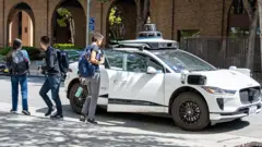 Pessoas embarcando e desembarcando de um carro autônomo Waymo