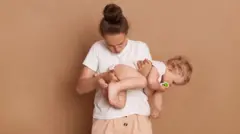 Una madre inspecciona el pañal de su bebé