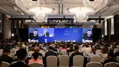 Các bộ trưởng và đại biểu lắng nghe bài phát biểu của Tổng thống Ukraine Volodymyr Zelenskiy