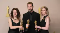 Mstyslav Chernov junto a las productoras de cine Raney Aronson-Rath (izquierda) y Michelle Mizner (derecha)