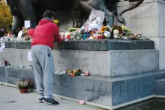 Persona depositando flores en un monumento
