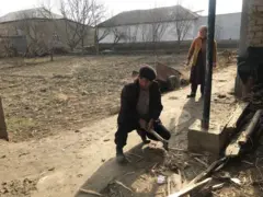 Ўтин ёраётган эркак ва унинг ишини кузатиб турган аёл