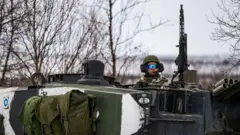 A Finnish soldier of the Finnish-Swedish Division rides the Leopard 2A6 battle tank, during a demonstration of border crossing by Swedish and Finnish troops as part of the NATO Nordic Response 24 military exercise 