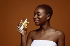 Femme qui boit de l'eau citronnée