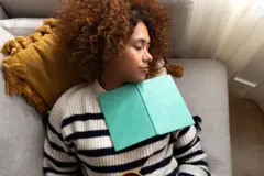 Uma mulher dormindo com um livro em seu colo