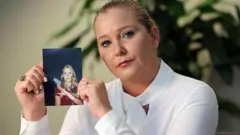 Virginia Giuffre sujeta una fotografía de ella más joven