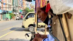यात्रुको पर्खाइमा रिक्साचालक।