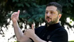 Зеленський відповідає на питання журналістів й руками допомагає собі пояснити думку жестами 