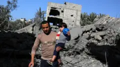 A man carries his child in front of a destroyed building and mounds of debris