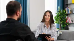 Una terapeuta conversa con un empleado 