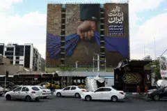 Automobili ispred bilborda na kom se vidi Ormuski moreuz