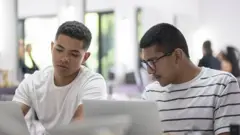 Dois jovens na frente de um laptop