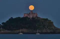 القمر الفراولة متوهجا فوق القلعة التاريخية على جبل سانت مايكل في كورنوال