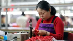 2025年4月8日，工人在廣西柳州融安縣一家電子廠間的生產線上加工數據線等電子產品。