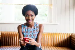 Jeune femme noire avec une tasse entre les mains