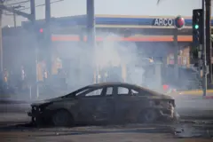 Um carro destruído na estrada durante confronto entre a polícia e manifestantes após detenções pelo Serviço de Imigração e Alfândega (ICE), na cidade de Paramount, no Condado de Los Angeles, Califórnia, EUA, em 7 de junho de 2025.