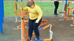 Niña con sobrepeso jugando al aire libre