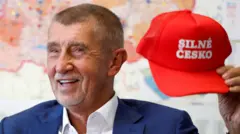 Бывший премьер-министр Чехии Андрей Бабиш держит кепку в стиле MAGA с надписью «Сильная Чехия»