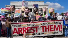 Manifestantes seguram efígies de integrantes do governo Trump, bem como cartazes pedindo sua prisão