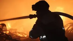 Пожежник ДСНС гасить пожежу на Дніпропетровщині