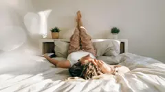 Ayaklarını duvara dayamış bir kadın