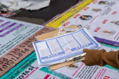 mão com cédulas de votação