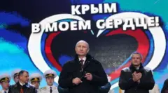 Президент Росії Володимир Путін і "прем'єр-міністр" Криму Сергій Аксьонов (праворуч) на мітингу на Червоній площі в Москві 18 березня 2014 року з нагоди "повернення" Криму 