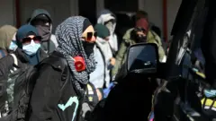 يغادر أفراد من عائلات أسترالية يُعتقد أنهم مرتبطون بمسلحي تنظيم الدولة الإسلامية مخيم روج قرب ديريك في سوريا، في 16 فبراير/شباط 2026.