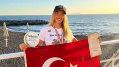 Eda Savcıgil İtalya'daki yarıştan sonra elinde Türk bayrağını tutuyor
