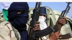 Aworan awọn agbebọn meji to boju-bomu pẹlu ibọn ti wọn gbe dani