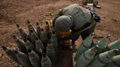 جندي إسرائيلي يحمل قذائف مدفعية