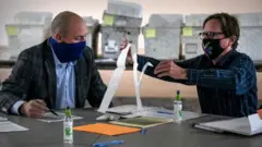 Election officials looking at absentee ballots