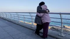 Dete i žena zagrljeni u Bejrutu