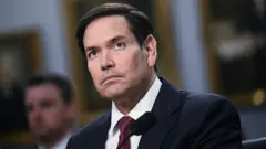 وزير الخارجية الأمريكي، ماركو روبيو، يجلس أمام لجنة فرعية بمجلس النواب في واشنطن العاصمة في 21 مايو/أيار 2025 وأمامه ميكروفون.