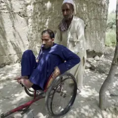 رجل يدفع آخر على كرسي متحرك